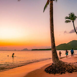 Tourists Meander Along the Shoreline,their Footsteps Leaving Imprints in the Soft Sand as They Soak in the Breathtaking Beauty of the Beach against the Backdrop of An Orange-Tinged Sky during the Enchanting Moments of Sunset,a Scene of Tranquil Serenity and Natural Splendor that Inspires Awe and Wonder.